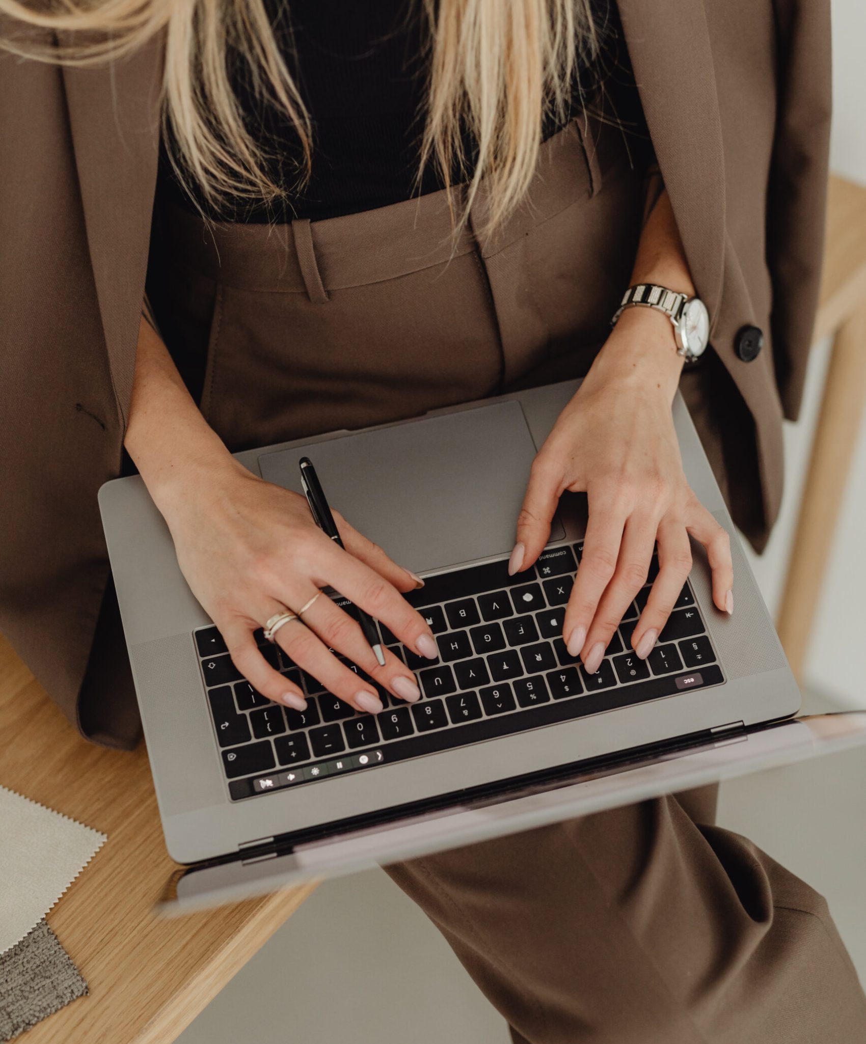 kaboompics_young-entrepreneur-dressed-in-brown-suit-holds-laptop-27938